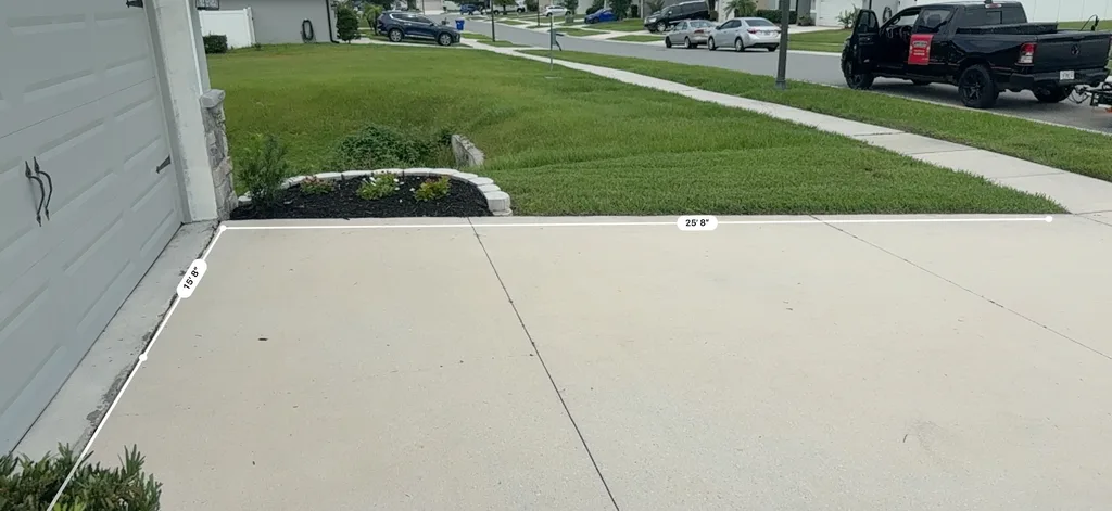 Clean concrete driveway and walkway running from the street to a planted front bed