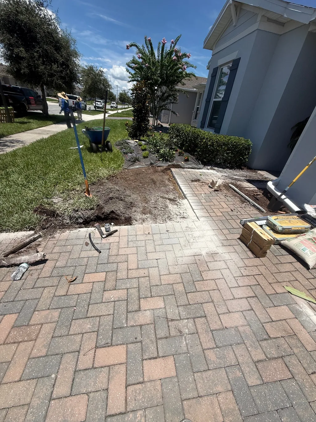 Finished paver walkway in a herringbone pattern running beside a residential lawn