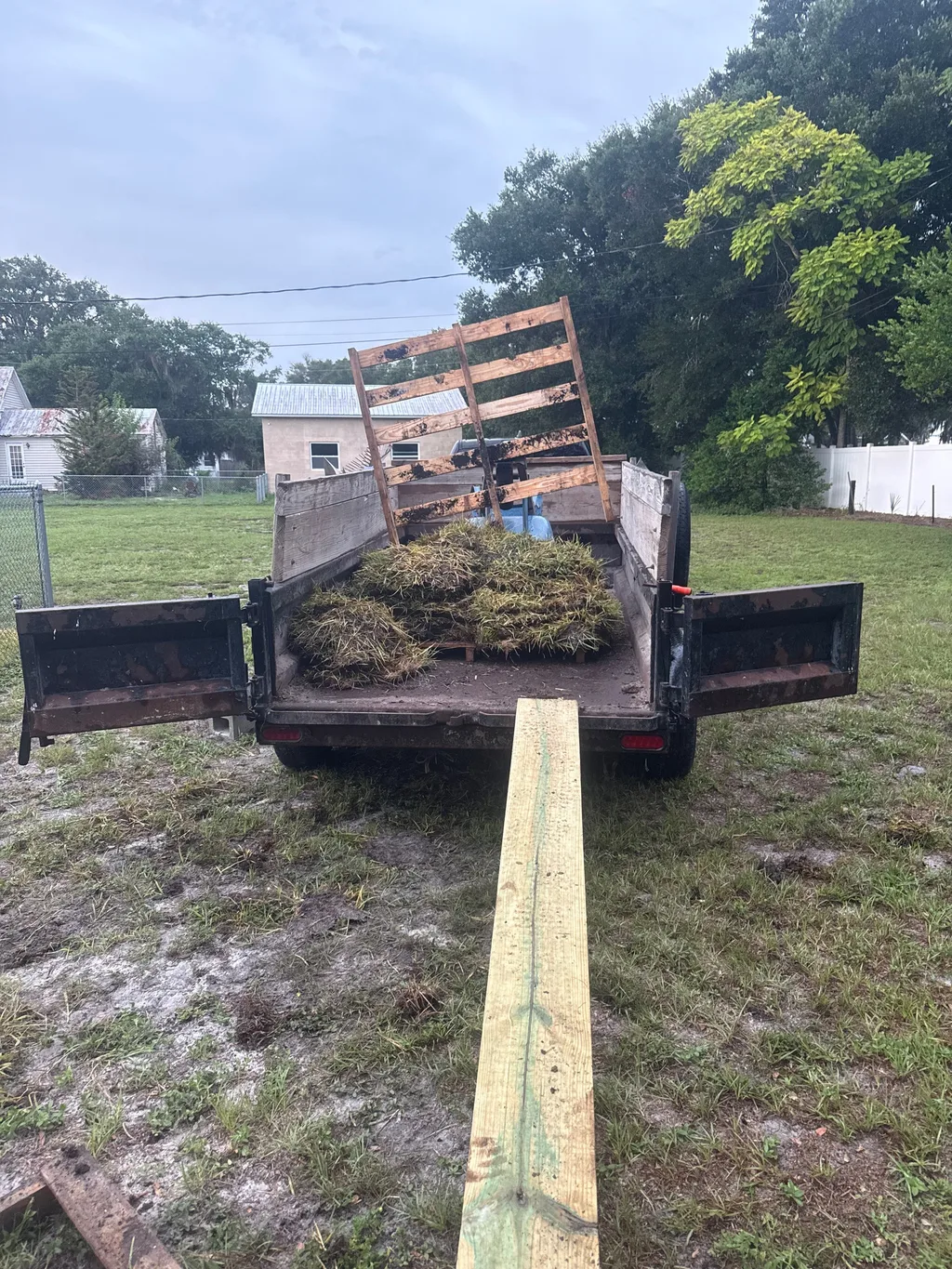 Pickup bed loaded with yard waste and cut vegetation during a property cleanup
