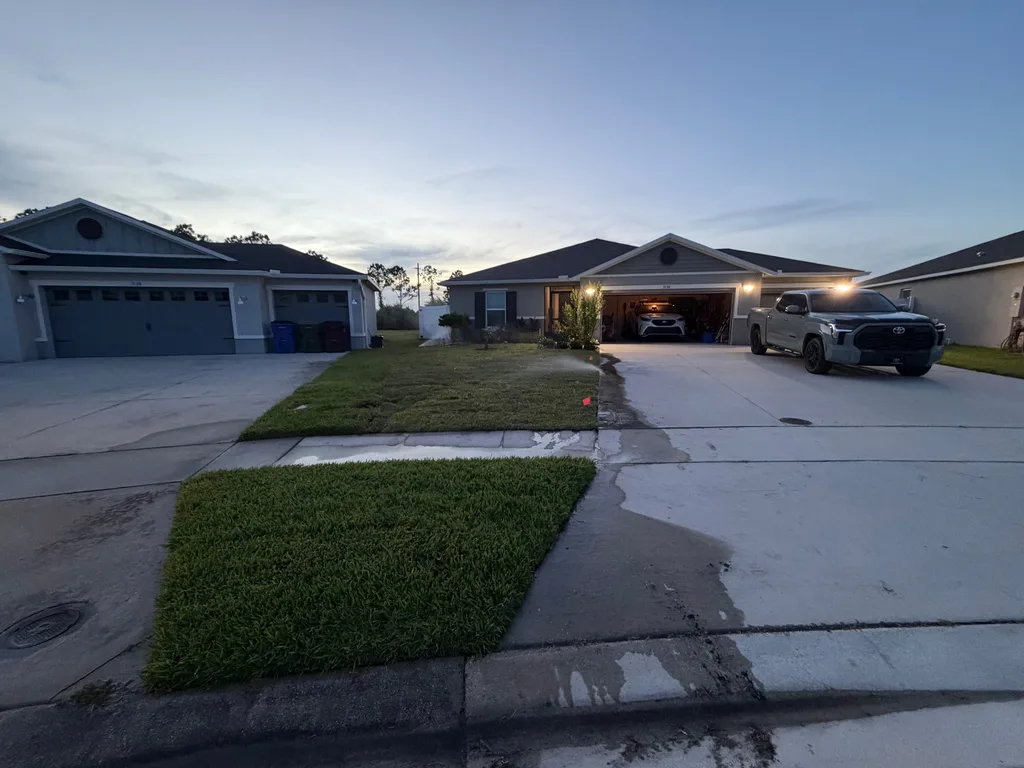 Concrete driveway and walkway still wet in front of a home at dusk